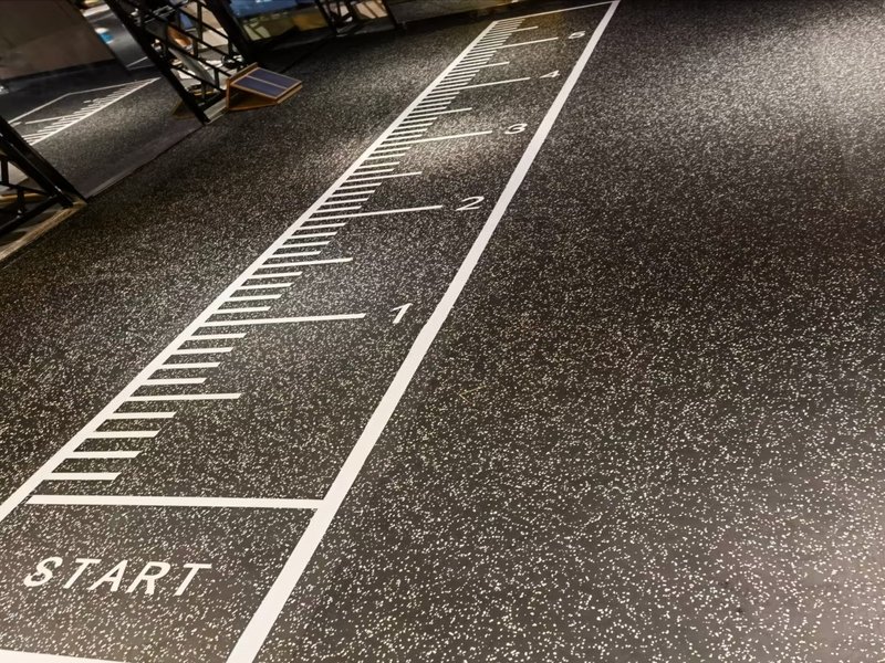 Een gedetailleerde close-up opname van de textuur van een rubberen sportschoolvloer.